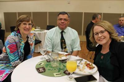 Three UNT staff members posing for a picture at a table
